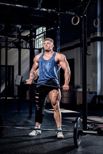 About professional powerlifter with bandage leg holding sports hammer warming up before training injury recovery sport commitment motivation 613910 21610