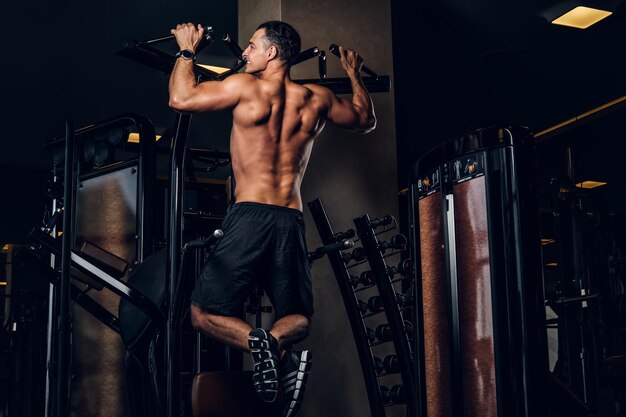 About young sportive man is doing exercises his back dark gym club 613910 14517
